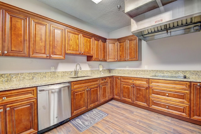 kitchen featuring sink, light hardwood / wood-style flooring, stainless steel dishwasher, a textured ceiling, and range hood