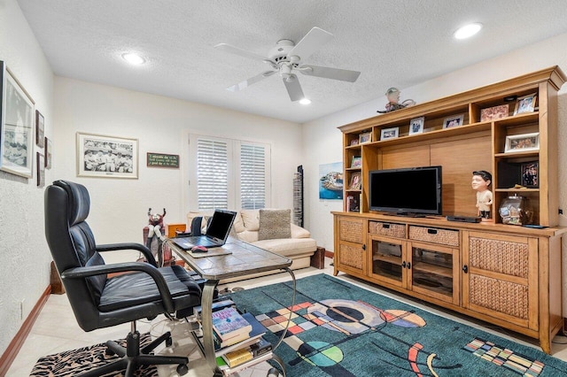 tiled office space featuring ceiling fan and a textured ceiling