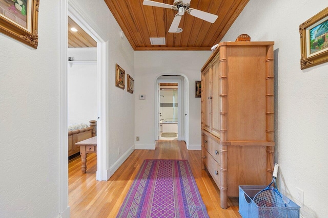 corridor with crown molding, wooden ceiling, and light wood-type flooring