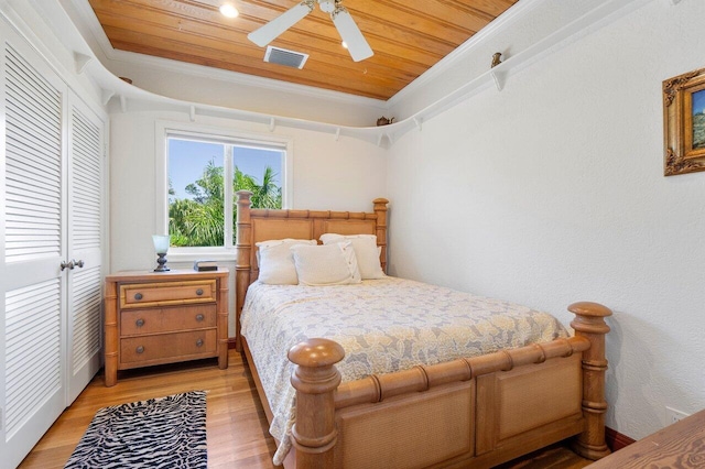 bedroom featuring light hardwood / wood-style floors, ceiling fan, ornamental molding, and wood ceiling