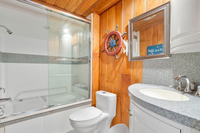 full bathroom featuring vanity, toilet, decorative backsplash, and shower / bath combination with glass door