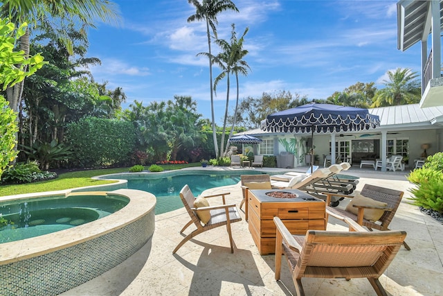 view of pool featuring a patio area, an in ground hot tub, and a fire pit