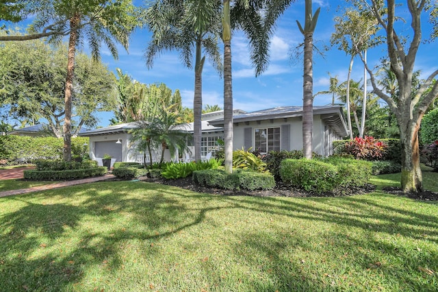 ranch-style home featuring a garage and a front yard