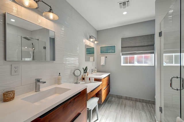 bathroom with backsplash, vanity, and a shower with shower door