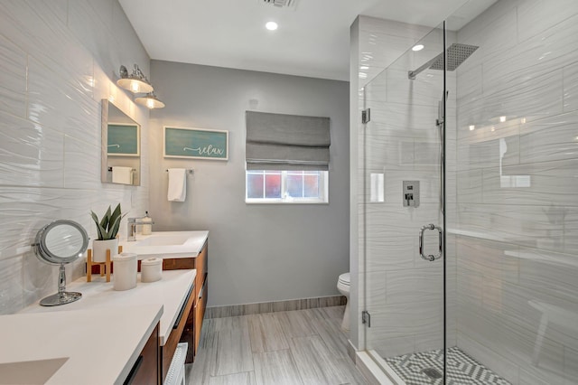 bathroom with vanity, toilet, and a shower with shower door