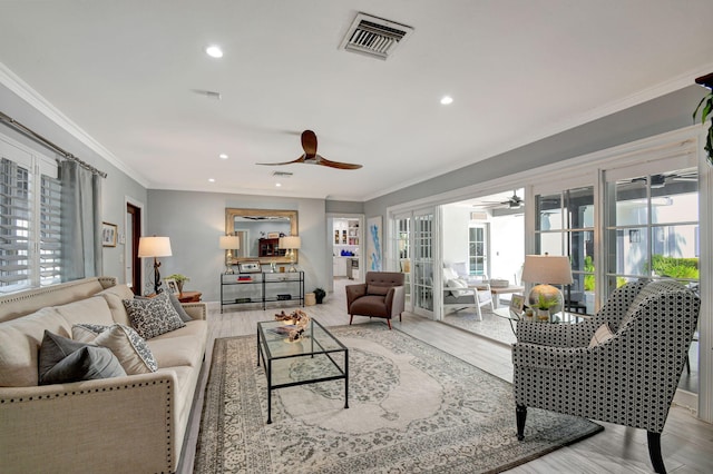 living room with crown molding, ceiling fan, and light wood-type flooring