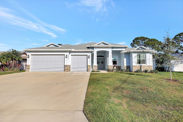 view of front of house with a front lawn, stone siding, an attached garage, and concrete driveway