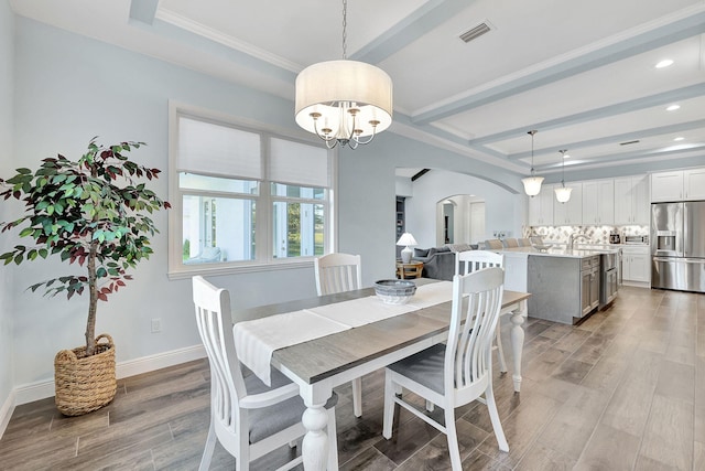 dining space with beam ceiling and a notable chandelier