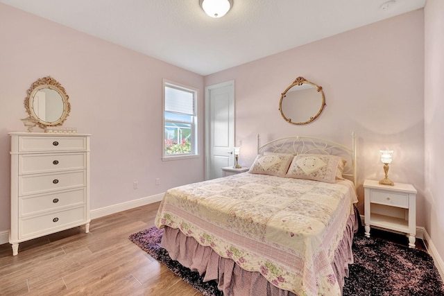 bedroom featuring light wood-style floors and baseboards