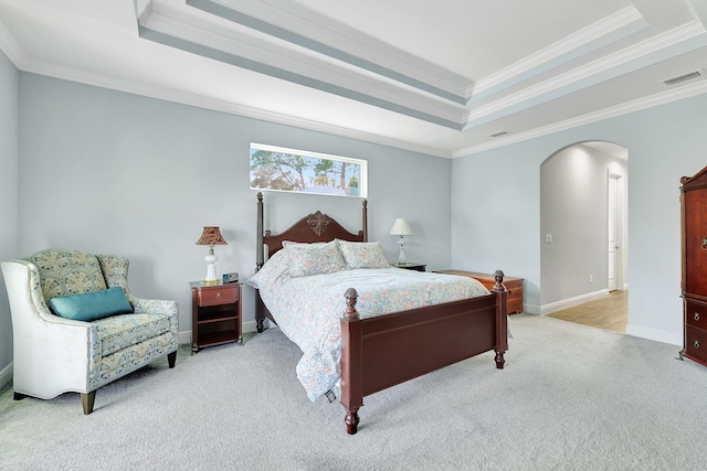 bedroom featuring light carpet, visible vents, a raised ceiling, and arched walkways