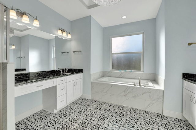 bathroom featuring a garden tub, vanity, and baseboards