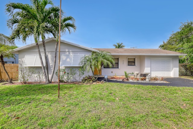 single story home with a garage, driveway, fence, a front yard, and stucco siding