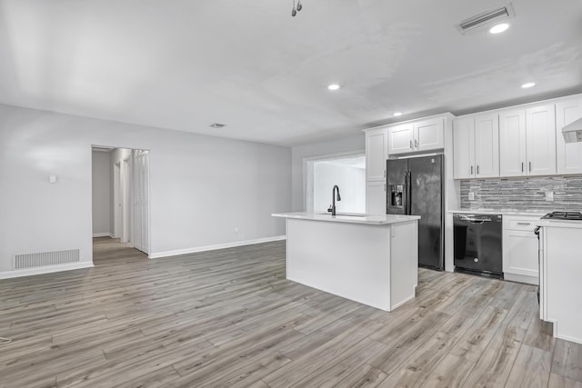 kitchen with light countertops, visible vents, a sink, and black appliances