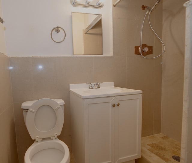 full bathroom featuring a stall shower, tile walls, toilet, and vanity