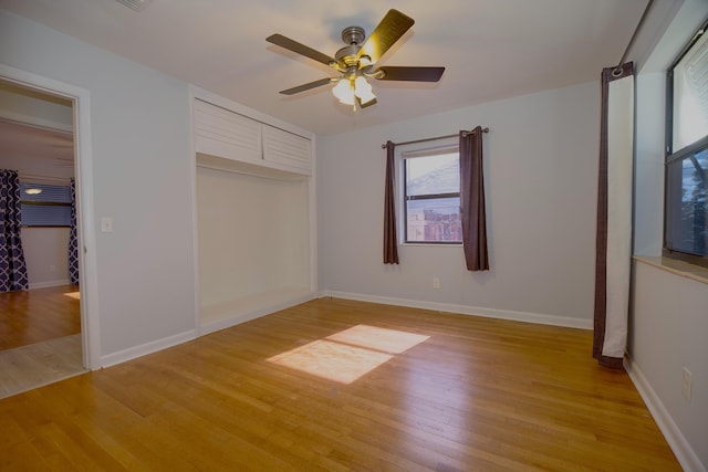 unfurnished bedroom with light wood-style floors, baseboards, and a ceiling fan