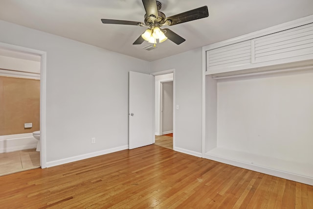 unfurnished bedroom featuring ensuite bathroom, light wood-style flooring, visible vents, baseboards, and a closet