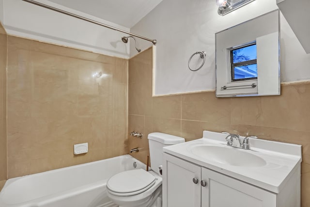 bathroom with toilet, vanity, tile walls, and bathing tub / shower combination