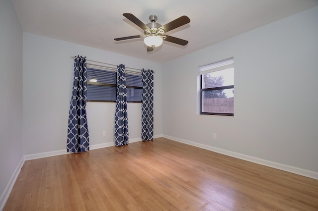 empty room with ceiling fan, baseboards, and wood finished floors