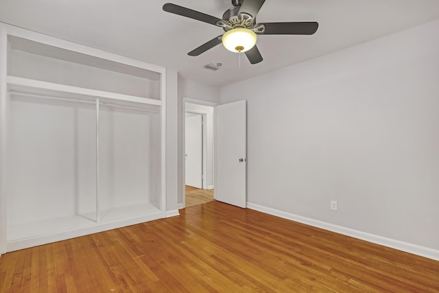 unfurnished bedroom with light wood finished floors, a closet, visible vents, ceiling fan, and baseboards