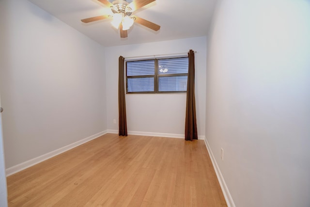 spare room featuring ceiling fan, light wood-style flooring, and baseboards