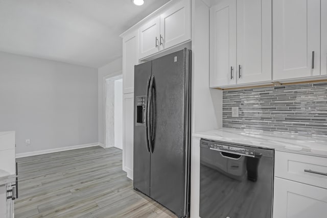 kitchen with tasteful backsplash, baseboards, light stone counters, black appliances, and white cabinetry