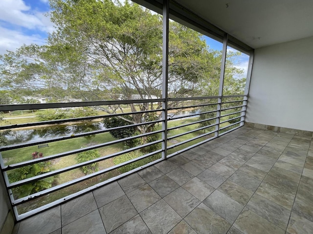 unfurnished sunroom with a water view