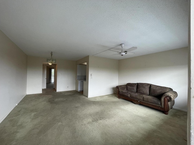 living room with ceiling fan, a textured ceiling, and dark carpet