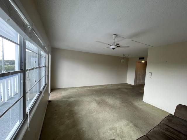 carpeted spare room featuring ceiling fan and a textured ceiling