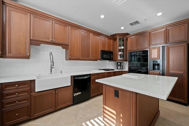 kitchen with sink, light tile patterned floors, backsplash, a kitchen island, and black appliances