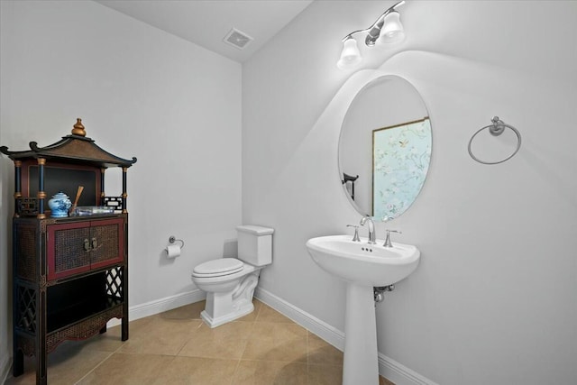 bathroom featuring tile patterned flooring, vaulted ceiling, and toilet