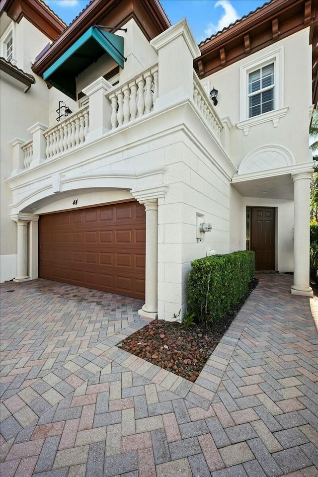 view of front of property featuring a balcony and a garage