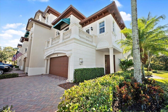 view of front of property featuring a balcony and a garage