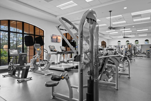 workout area with a paneled ceiling and ceiling fan