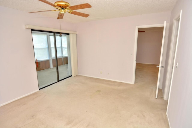 unfurnished room featuring a textured ceiling, light colored carpet, and ceiling fan