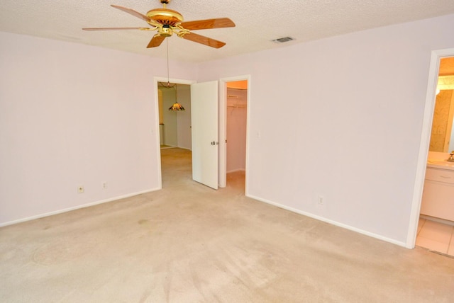 carpeted spare room featuring a textured ceiling and ceiling fan