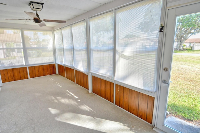 unfurnished sunroom with ceiling fan