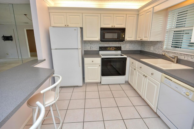 kitchen with light tile patterned flooring, decorative backsplash, white appliances, and sink