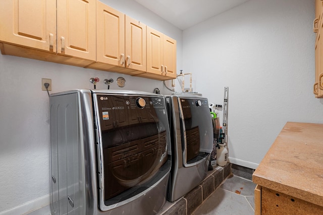 washroom with washer and dryer, cabinets, and dark tile patterned flooring