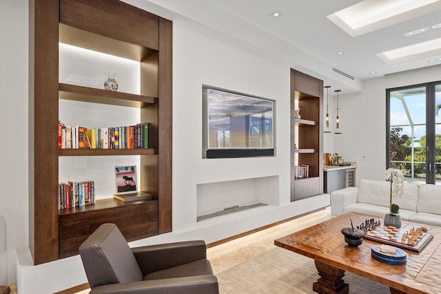 living room featuring built in features, a skylight, visible vents, and recessed lighting