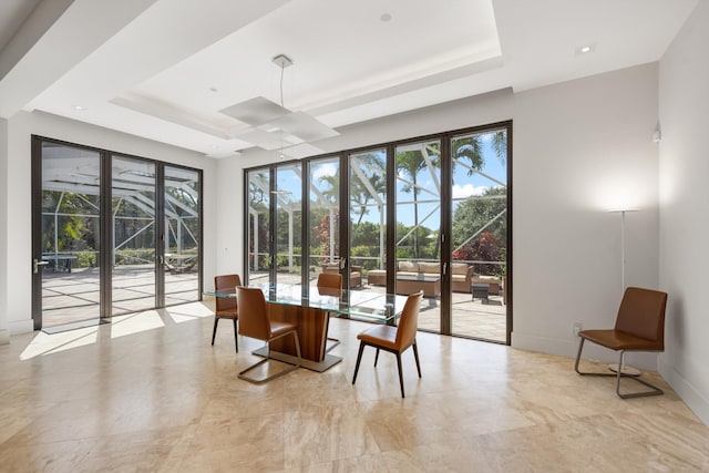 dining room with baseboards, a tray ceiling, and a wealth of natural light