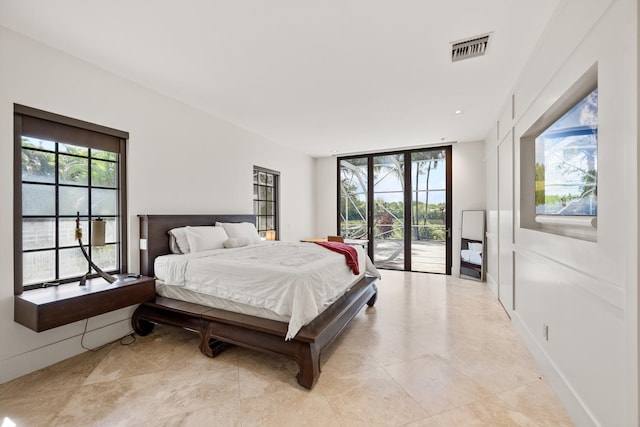 bedroom with access to outside, baseboards, visible vents, and expansive windows