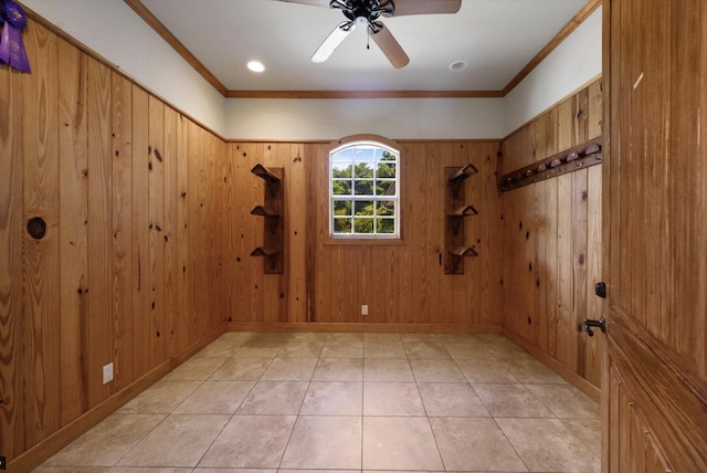 unfurnished room featuring wooden walls, ceiling fan, and ornamental molding