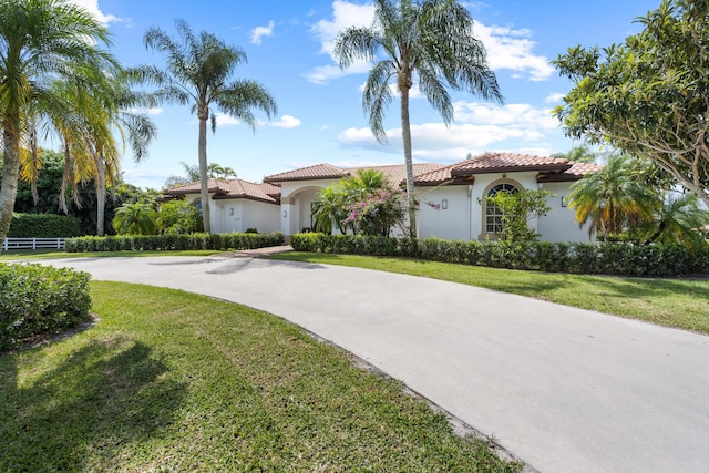 mediterranean / spanish-style house with a front yard