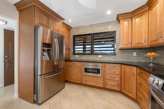 kitchen featuring light tile patterned flooring, dark stone countertops, backsplash, and appliances with stainless steel finishes