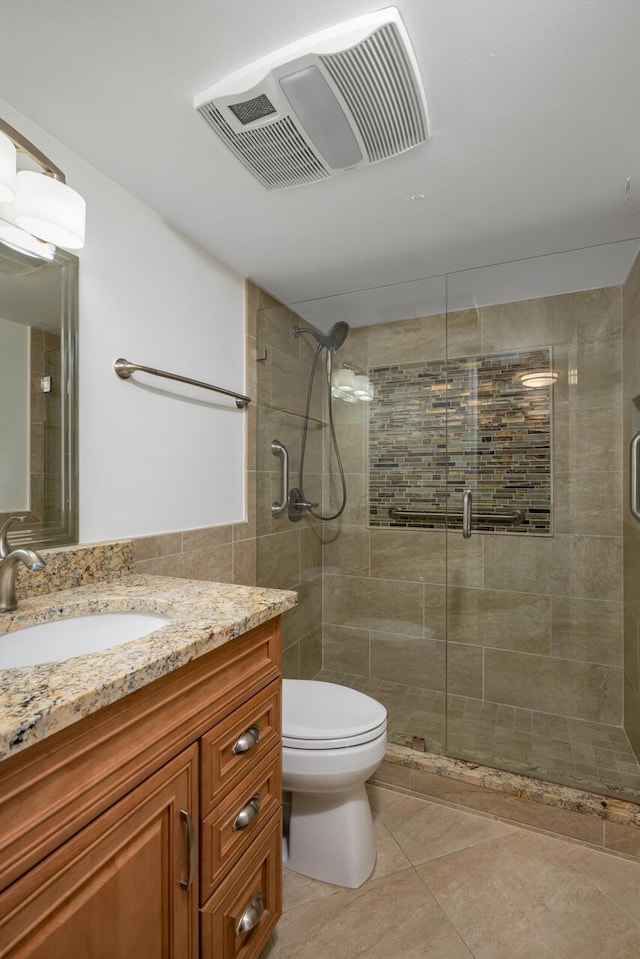 bathroom with tile patterned floors, vanity, toilet, and walk in shower