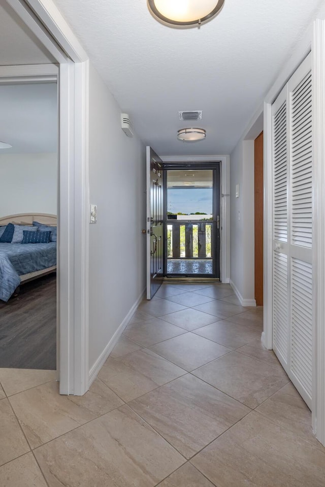 corridor featuring light tile patterned floors