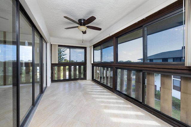 unfurnished sunroom featuring ceiling fan