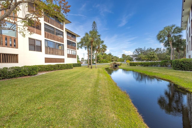 view of community with a water view and a lawn