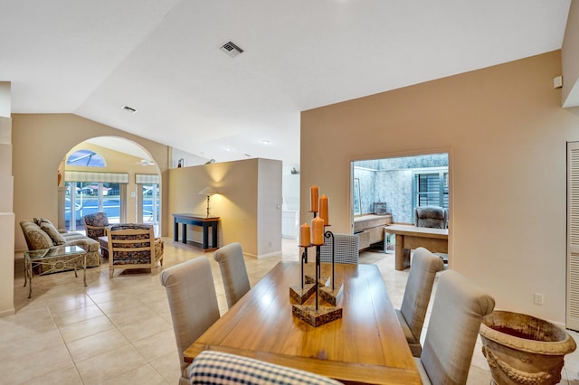 dining area featuring vaulted ceiling and light tile patterned floors