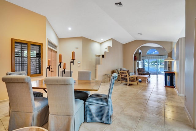 dining room featuring vaulted ceiling and light tile patterned flooring